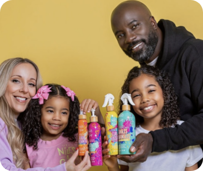 Colter family holding Niles and Chaz Pizzaz! kids hair care products for mixed texture hair